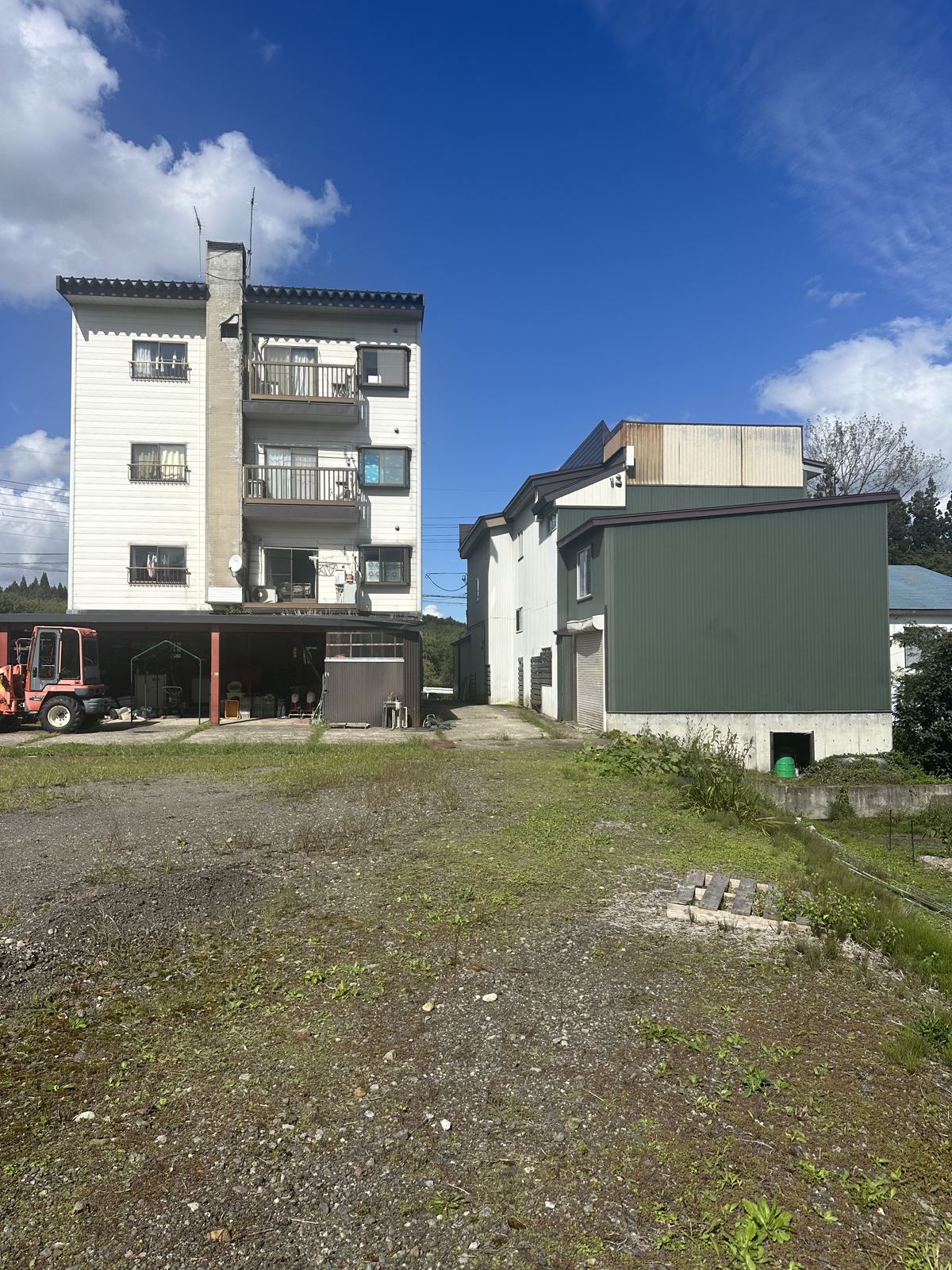 Both buildings seen across the open land